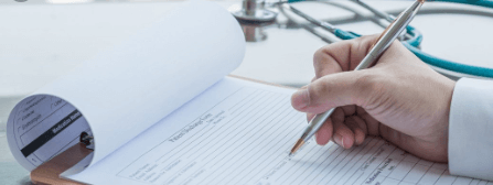 nurse writing up notes with a stethoscope in the background